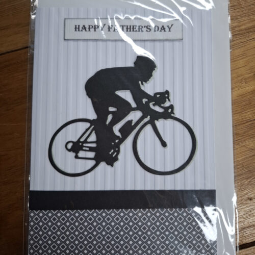 Silhouette of a man riding a bicycle with happy father's day message on card