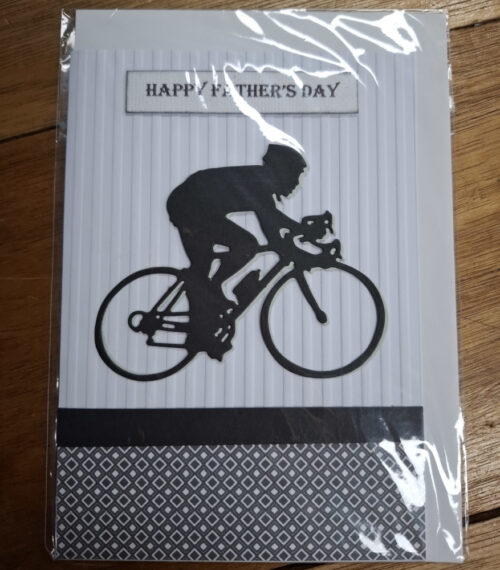 Silhouette of a man riding a bicycle with happy father's day message on card
