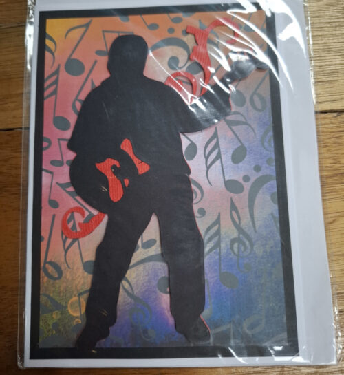 figure rocking away on a quitar on a card