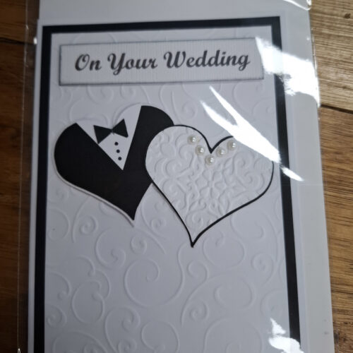 two hearts looking like a wedding dress and tux on a card